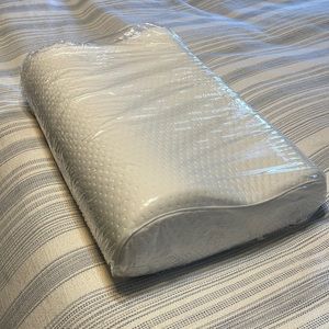 Brand new Tempur-pedic head and neck pillow with original packaging.